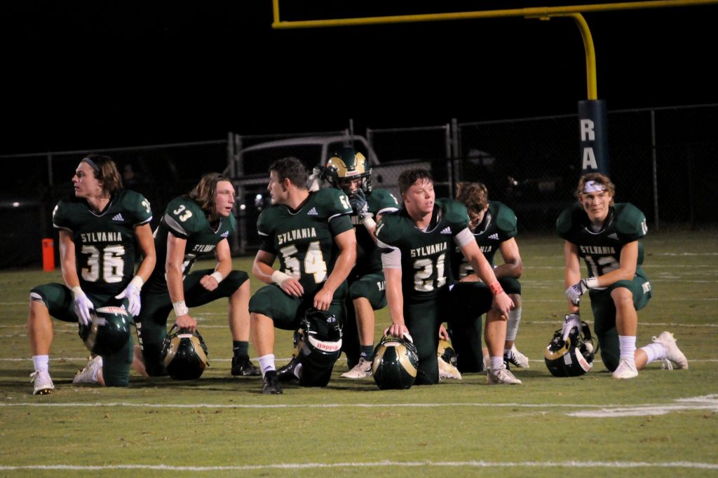 Sylvania defensive players take a break during an injury timeout.